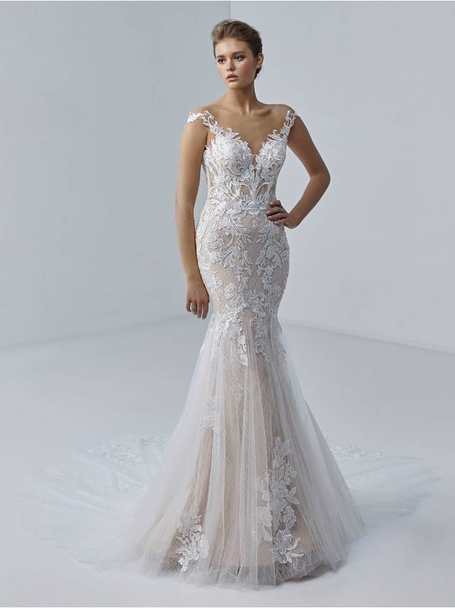 Code: Etoile Stephanie - IN STUDIO Code: Etoile Stephanie - IN STUDIO The elegant Stéphanie gown features a unique, off-shoulder sleeve design with illusion tulle, a soft and comfortable stretch jersey lining, a soft flowing hem, and body-contouring, sparkling baroque floral lace.Colour Options: Ivory/Nude/Nude OR Ivory/Ivory/Nude OR Ivory/Sand/Nude