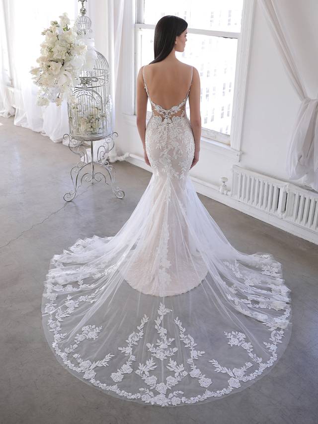 Code: Blue By Enzoani Olana Code: Blue By Enzoani Olana Like a gorgeous upgrade on our beloved Nadia gown. Combined with sparkling sequined Chantilly lace, the beloved thick embroidered floral lace stands out even more with figure-enhancing illusion side panels and the low, open illusion lace back. The detachable, off-shoulder lace and tulle split cape creates even more jaw-dropping drama. Colour Options: Ivory/Nude/Nude OR Ivory/Ivory/Nude OR Ivory/Sand/Nude OR Ivory/Ivory/Ivory
