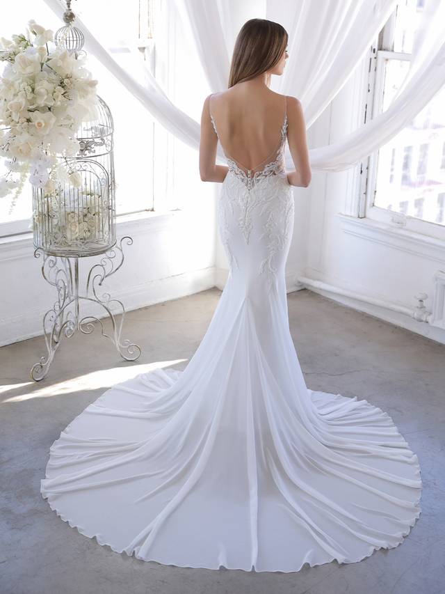 Code: Blue By Enzoani Olivette Code: Blue By Enzoani Olivette This mermaid gown is all about clean lines and sleek sophistication with a twist – elegant embroidered lace beautifully trails down from the sexy plunging V-neckline and weaves throughout the illusion back for a cohesive look. The light-as-air chiffon and tulle skirt is modern and minimalist, perfect for brides who want an effortlessly glam look. Colour Options: Ivory/Nude OR Ivory/Ivory