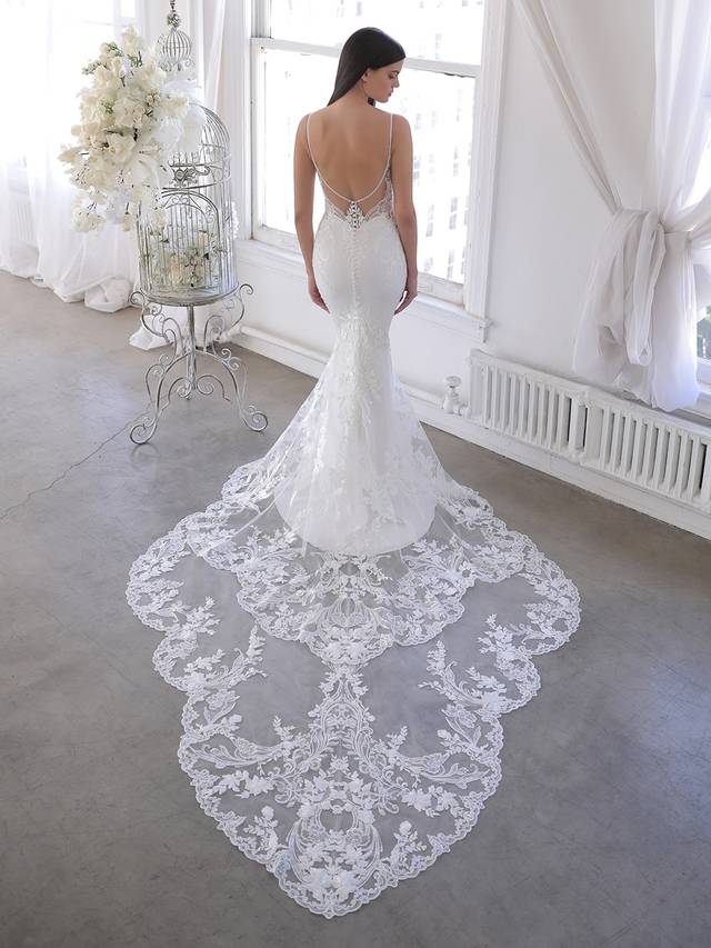 Code: Blue By Enzoani Omari (with train) Code: Blue By Enzoani Omari (with train) Delicate, dreamy, dramatic – Omari is perfect for the modern bride who wants both exquisite detailing and unique versatility. Intricate floral embroidered lace travels from the romantic sweetheart neckline bodice and low illusion back down to the soft and sleek stretch georgette skirt. The gorgeous scalloped lace hem easily connects to the detachable lace train extension for that extra glam option for the ceremony. Colour Options: Ivory/Nude OR Ivory/Ivory
