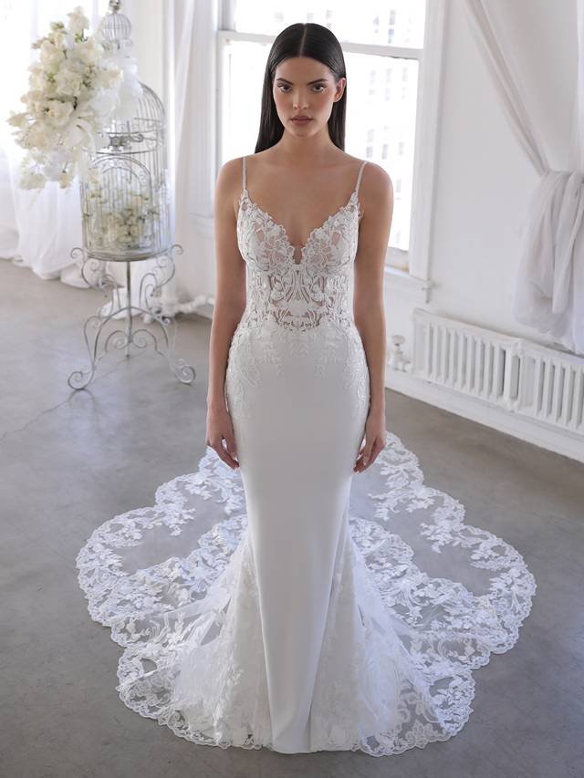 Code: Blue By Enzoani Omari Code: Blue By Enzoani Omari Delicate, dreamy, dramatic – Omari is perfect for the modern bride who wants both exquisite detailing and unique versatility. Intricate floral embroidered lace travels from the romantic sweetheart neckline bodice and low illusion back down to the soft and sleek stretch georgette skirt. The gorgeous scalloped lace hem easily connects to the detachable lace train extension for that extra glam option for the ceremony.Colour Options: Ivory/Nude OR Ivory/Ivory