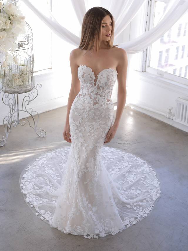 Code: Blue By Enzoani Orrie Code: Blue By Enzoani Orrie Orrie is the answer for our brides who love the Naroza but want the option to completely remove the long off-shoulder sleeves. Our beloved thick embroidered floral lace is front and center on this gown with a deep sweetheart neckline and eye-catching illusion corset-style back with covered buttons.Colour Options: Ivory/Sand/Nude OR Ivory/Ivory/Nude OR Ivory/Nude/Nude OR Ivory/Ivory/Ivory