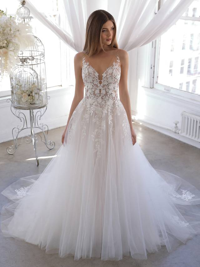 Code: Enzoani Blue Olani - ARRIVING SOON Code: Enzoani Blue Olani - ARRIVING SOON A delicate and sexy illusion lace back and V-neckline adorned with beautiful floral embroidered lace gorgeously trickles down to the dreamiest organza, glitter tulle and tulle skirt. The gown will sparkle and shine at every turn, creating the most heavenly effect. Romantic floral lace appliques peeking through the ethereal A-line skirt add even more playful beauty for brides as they walk down the aisle.Colour Options: Ivory/Nude/Nude OR Ivory/Ivory/Nude OR Ivory/Ivory/Ivory