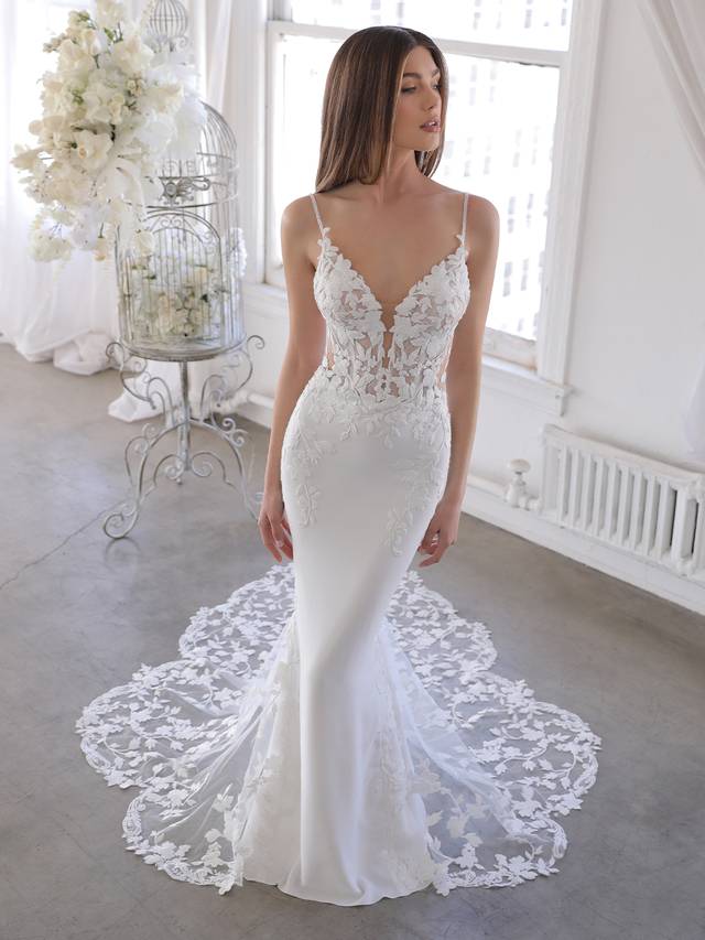 Code: Enzoani Blue Oliviana - ARRIVING SOON Code: Enzoani Blue Oliviana - ARRIVING SOON This gorgeous mermaid gown features the sought-after thick floral embroidered lace of bestselling styles on a plunging illusion sweetheart neckline bodice with sweet spaghetti straps. The illusion lace back is sure to keep all eyes on the bride, especially with the lace beautifully cascading down the softest stretch georgette and tulle skirt featuring a signature Enzoani scalloped lace train.Colour Options: Ivory/Nude OR Ivory/Ivory