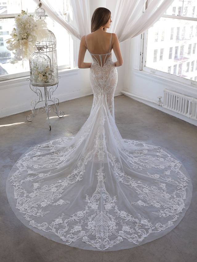 Code: Enzoani Blue Olivine - ARRIVING SOON Code: Enzoani Blue Olivine - ARRIVING SOON Olivine is for the bride who wants glamour, drama, and sexy sophistication in one unique look. Sweetly delicate spaghetti straps frame the deep sweetheart neckline bodice that leads to the most exquisite beaded, illusion corset-style back. The back lace placement flatters the figure and draws the eye down to the breathtaking glitter tulle and soft tulle skirt and dramatic train. Colour Options: Ivory/Nude/Nude OR Ivory/Ivory/Nude OR Ivory/Sand/Nude OR Ivory/Ivory/Ivory