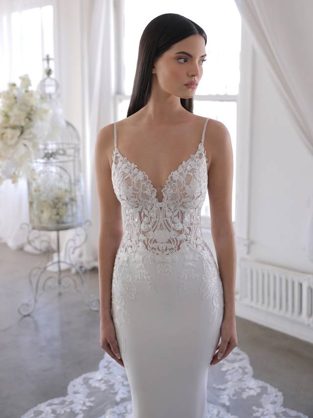 Code: Enzoani Blue Omari Code: Enzoani Blue Omari Delicate, dreamy, dramatic – Omari is perfect for the modern bride who wants both exquisite detailing and unique versatility. Intricate floral embroidered lace travels from the romantic sweetheart neckline bodice and low illusion back down to the soft and sleek stretch georgette skirt. The gorgeous scalloped lace hem easily connects to the detachable lace train extension for that extra glam option for the ceremony. Colour Options: Ivory/Nude OR Ivory/Ivory