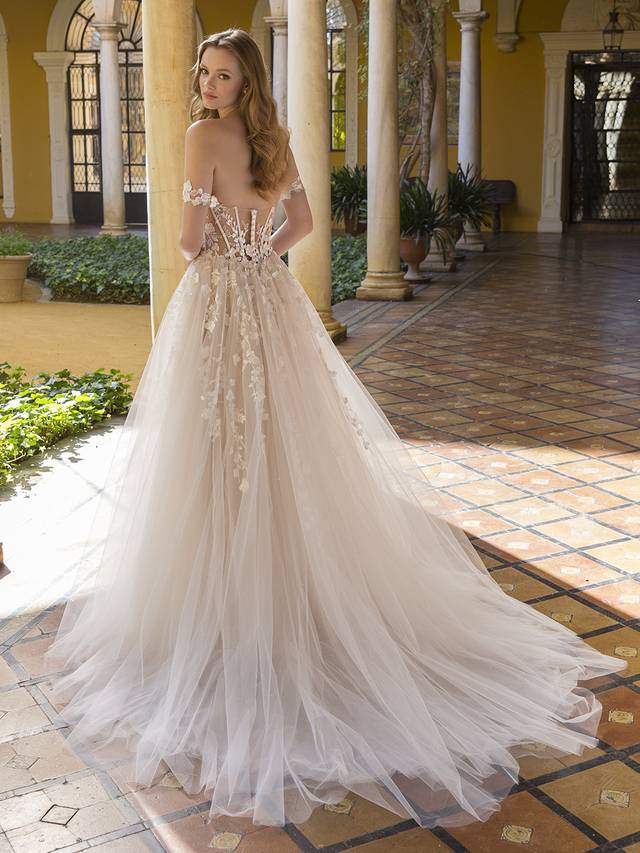 Code: Blue By Enzoani Palmer Code: Blue By Enzoani Palmer This A-line beauty will take your breath away with its soft beauty and striking detailing. From the uniquely crafted sweetheart bodice to the illusion open-corset back, this gown is straight out of a fairytale. The ethereal 3D motifs cascade beautifully into the dreamy tulle skirt. Feeling like changing up your bridal look? The floral off-the-shoulder straps may be detached to effortlessly create a reception-ready style.Colour Options: Ivory/Beige/Nude OR Ivory/Ivory/Nude OR Ivory/Ivory/Ivory
