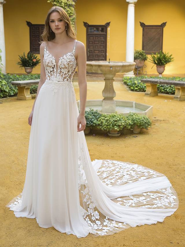 Code: Blue By Enzoani Parker Code: Blue By Enzoani Parker Feminine and sweet, this floaty, soft A-line gown is complete with layers of sheer chiffon skirt, a V-plunge illusion corset-style bodice with an open back, and the most gorgeous, whimsical cascading tulle trains covered in delicate botanical appliques. This unique composing of exquisite laser-cut 3D lace and customized embroidered wild floral motifs trails from the bodice to its skirt, while the back slowly opens to show off a glamorous, dramatic train.Colour Options: Ivory/Nude OR Ivory/Ivory
