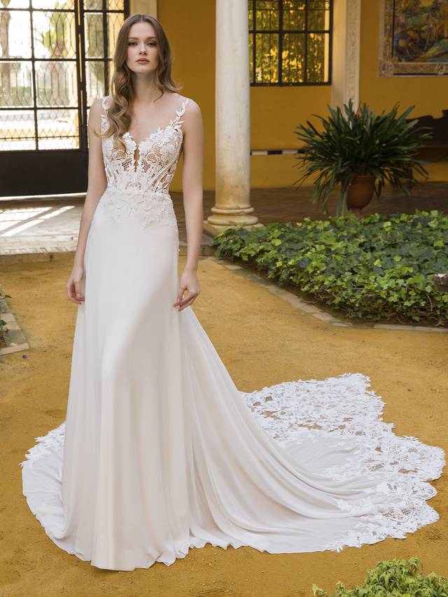 Code: Blue By Enzoani Patricia Code: Blue By Enzoani Patricia A relaxed take on our beloved A-line silhouettes, Patricia features a 3D floral embroidered lace unlike any other gown. This whimsical wedding dress features a chiffon skirt that falls effortlessly, meeting an intricate and exquisite train. Don’t miss out on the delicate illusion straps that lead into a sultry plunging V-back.Colour Options: Ivory/Nude OR Ivory/Ivory