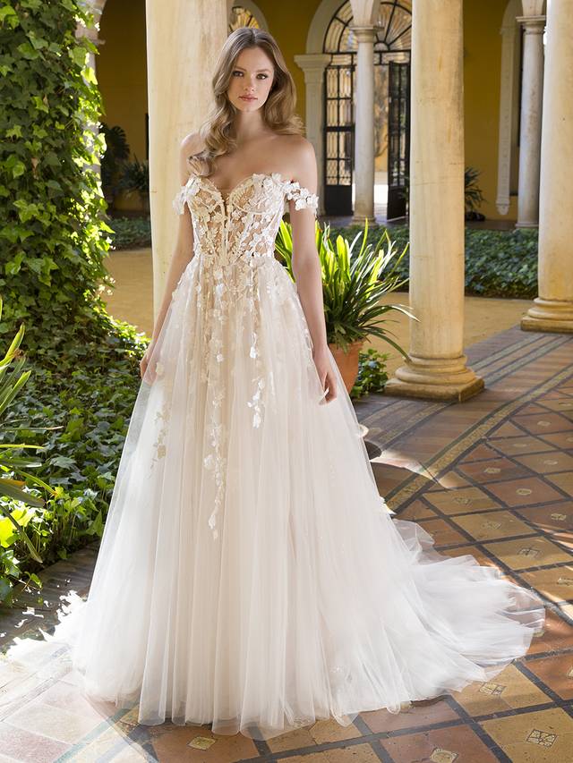Code: Enzoani Blue Palmer Code: Enzoani Blue Palmer This A-line beauty will take your breath away with its soft beauty and striking detailing. From the uniquely crafted sweetheart bodice to the illusion open-corset back, this gown is straight out of a fairytale. The ethereal 3D motifs cascade beautifully into the dreamy tulle skirt. Feeling like changing up your bridal look? The floral off-the-shoulder straps may be detached to effortlessly create a reception-ready style.Colour Options: Ivory/Beige/Nude OR Ivory/Ivory/Nude OR Ivory/Ivory/Ivory