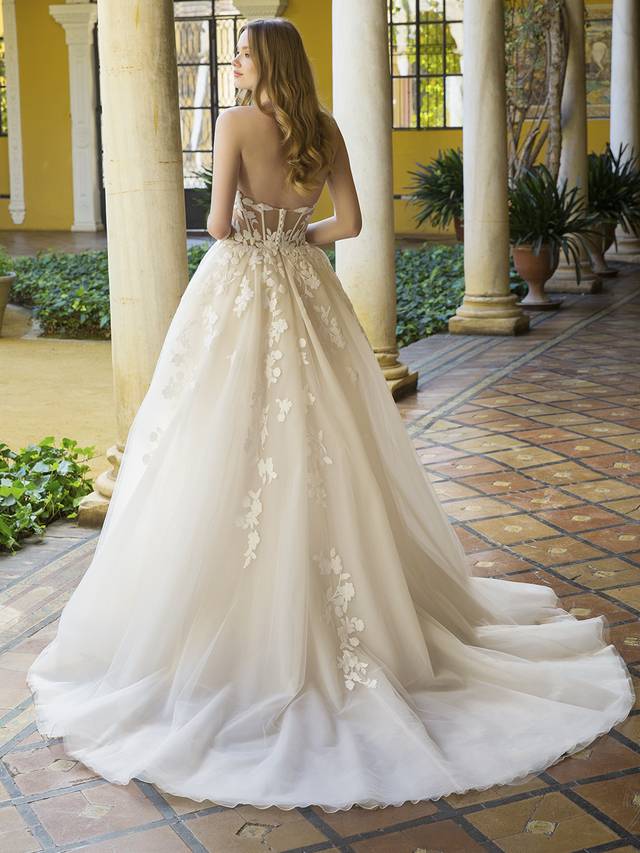 Code: Enzoani Blue Patience Code: Enzoani Blue Patience This modern princess bridal gown is truly a showstopper, meant to make you feel like a contemporary royal with its bespoke, captivating 3D floral motifs lace adorning the bodice and gently cascading down to the airy but voluminous skirt which complements rather than overpowers this graceful ball gown wedding dress. Details like the V-plunge illusion sweetheart neckline, ultra-glam corset-style bodice and the ball gown silhouette with a modern slit all contour the body and flatter the figure.Colour Options: Ivory/Beige/Nude OR Ivory/Ivory/Nude OR Ivory/Ivory/Ivory