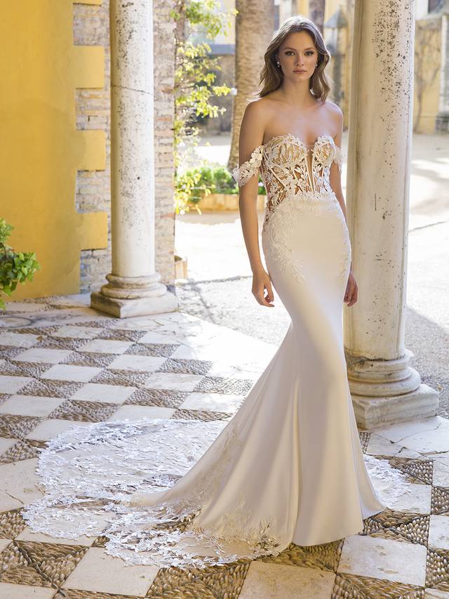 Code: Enzoani Blue Preston Code: Enzoani Blue Preston This figure-hugging mermaid gown is the perfect balance between classic romance and modern sexiness, featuring intricate floral embroidered lace on a plunging illusion sweetheart corset-style bodice with detachable 3D applique straps and the gorgeous signature Enzoani scalloped lace cut hem. The illusion boned ivory padded corset back adorned with covered buttons provides that elegant and unique touch while also giving extra structure and support.Colour Options: Ivory/Nude OR Ivory/Ivory