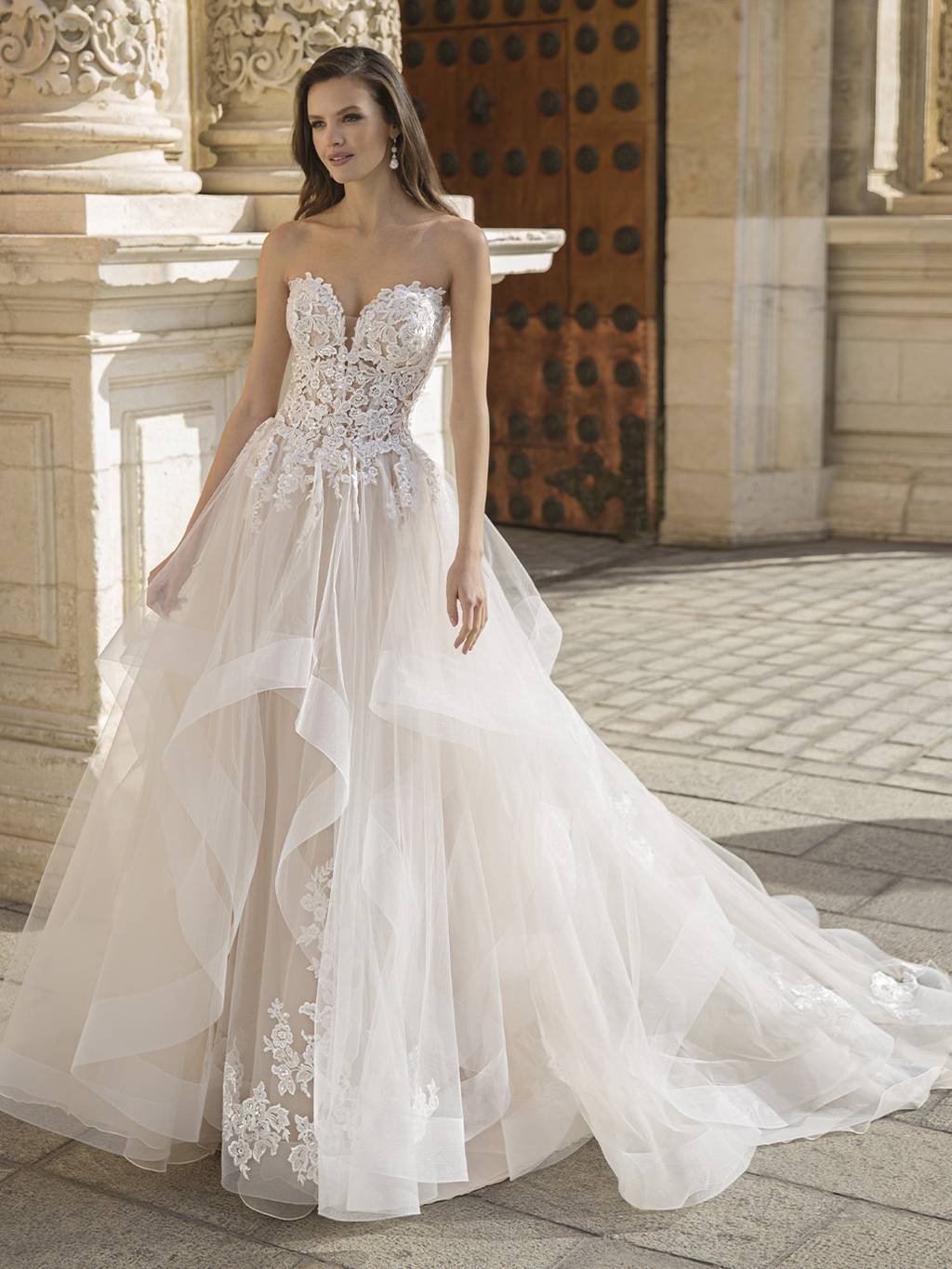 An ethereal, romantic gown with a sparkling illusion lace bodice leading to  a light, soft A-line tulle and chiffon skirt featuring a high