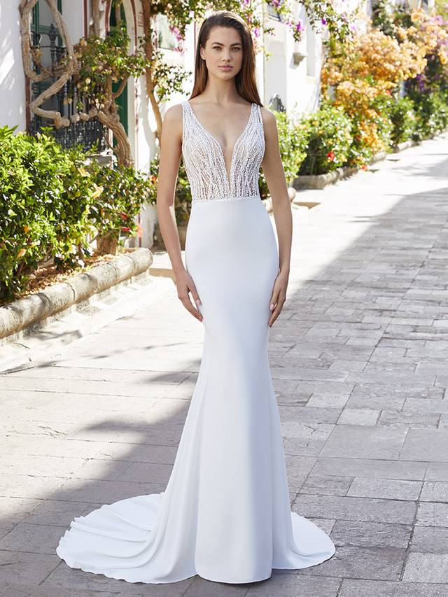 Code: Love By Enzoani Betsy Code: Love By Enzoani Betsy A real showstopper! The entire glittering bodice is adorned with a unique, one-of-a-kind beaded linear lace design for shimmering all-over sparkle. The V-plunge illusion neckline along with the low-cut back is effortlessly breathtaking. The modern and light stretch georgette mermaid skirt is an ideal contrast to the sexy, glittering bodice. The perfect balance between simplicity and glamour!Colour Options: Ivory/Nude OR Ivory/Ivory