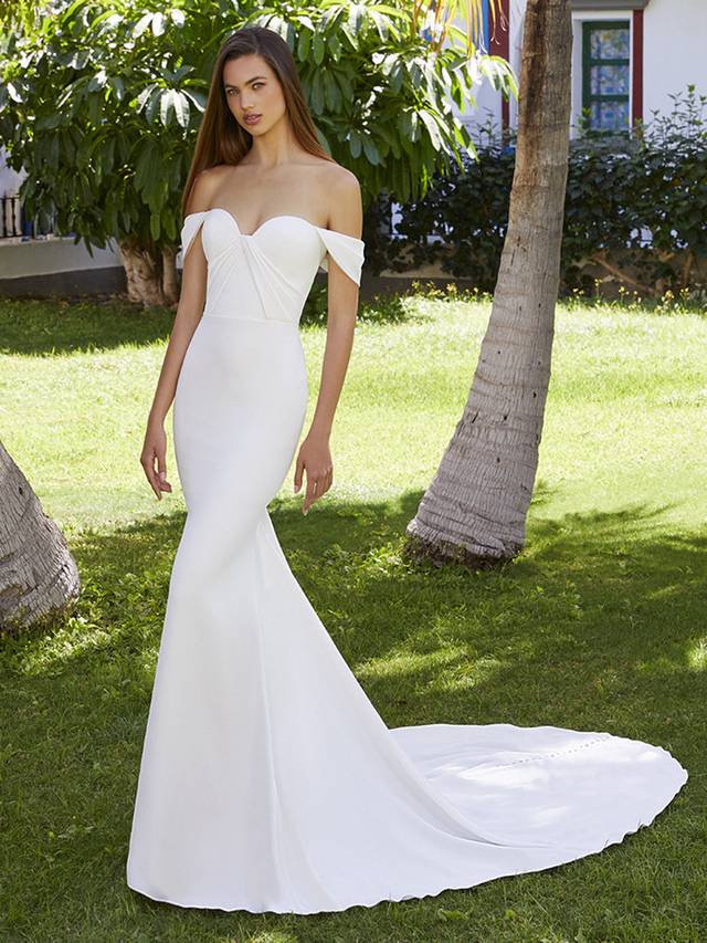 Code: Love By Enzoani Brianna Code: Love By Enzoani Brianna Shine bright in Brianna. Perfect for our flirty, modern brides, this beautiful stretch georgette mermaid wedding dress comfortably hugs the body, enhancing those curves. The classic sweetheart neckline, off-shoulder sleeves and pleated bodice detailing add extra romance to this sleek bridal look. Get ready for those incredible back shots with a one-of-kind illusion corset back, made sweeter with top to bottom fabric buttons.Colour Options: Ivory/Nude OR Ivory/Ivory