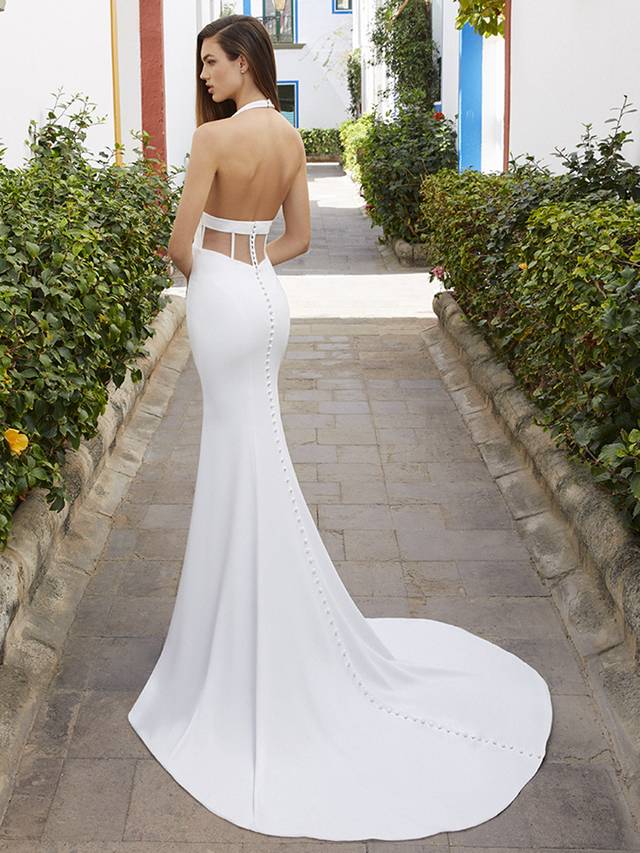 Code: Enzoani Love Brandi Code: Enzoani Love Brandi For our sexy brides who are full of confidence, just like you, Brandi is here to wow. This figure-hugging stretch georgette gown features a plunging halter neckline and a backless, sheer corset with exposed boning for the perfect embodiment of modern minimalism. This sophisticated gown is perfected with buttons lining the gown from top to bottom of the train. Colour Options: Ivory/Nude OR Ivory/Ivory
