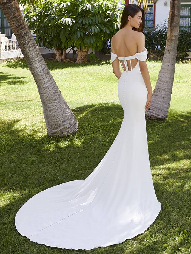 Code: Enzoani Love Brianna Code: Enzoani Love Brianna Shine bright in Brianna. Perfect for our flirty, modern brides, this beautiful stretch georgette mermaid wedding dress comfortably hugs the body, enhancing those curves. The classic sweetheart neckline, off-shoulder sleeves and pleated bodice detailing add extra romance to this sleek bridal look. Get ready for those incredible back shots with a one-of-kind illusion corset back, made sweeter with top to bottom fabric buttons.Colour Options: Ivory/Nude OR Ivory/Ivory