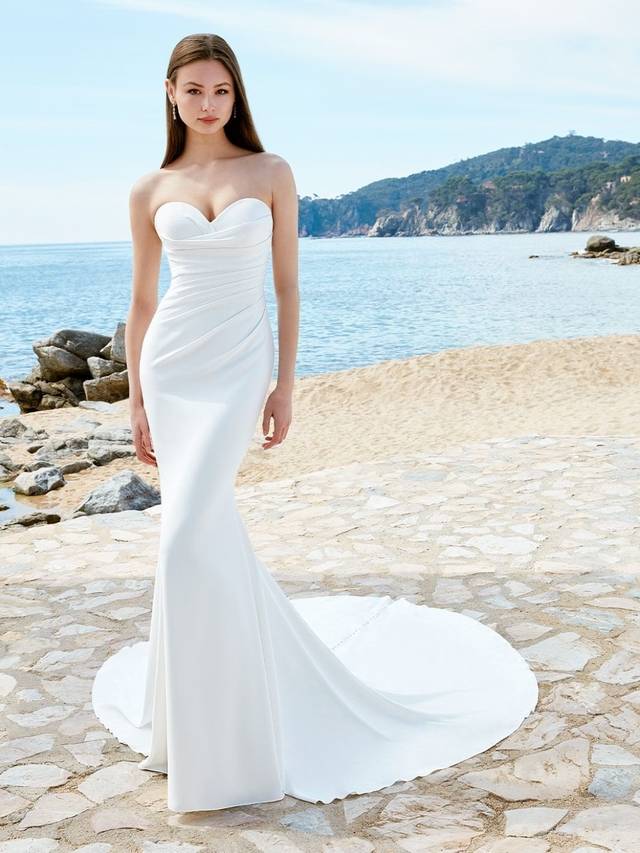Code: Love By Enzoani Arya Code: Love By Enzoani Arya ARYA is perfect for the modern bride-to-be. The artful draping detail over the bodice adds texture to this minimalist gown in lightweight stretch georgette. Its supportive internal boning makes it fit like a glove. A soft sweetheart neckline and the floral lace embellished sheer corset back also bring romantic softness to this sleek silhouette.Colour Options: Ivory/Nude OR Ivory/Ivory